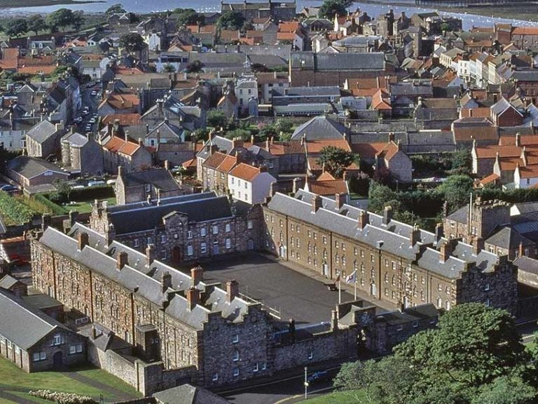 Aerial view of Berwick Barracks with historic buildings and rooftops in a coastal area - English Heritage